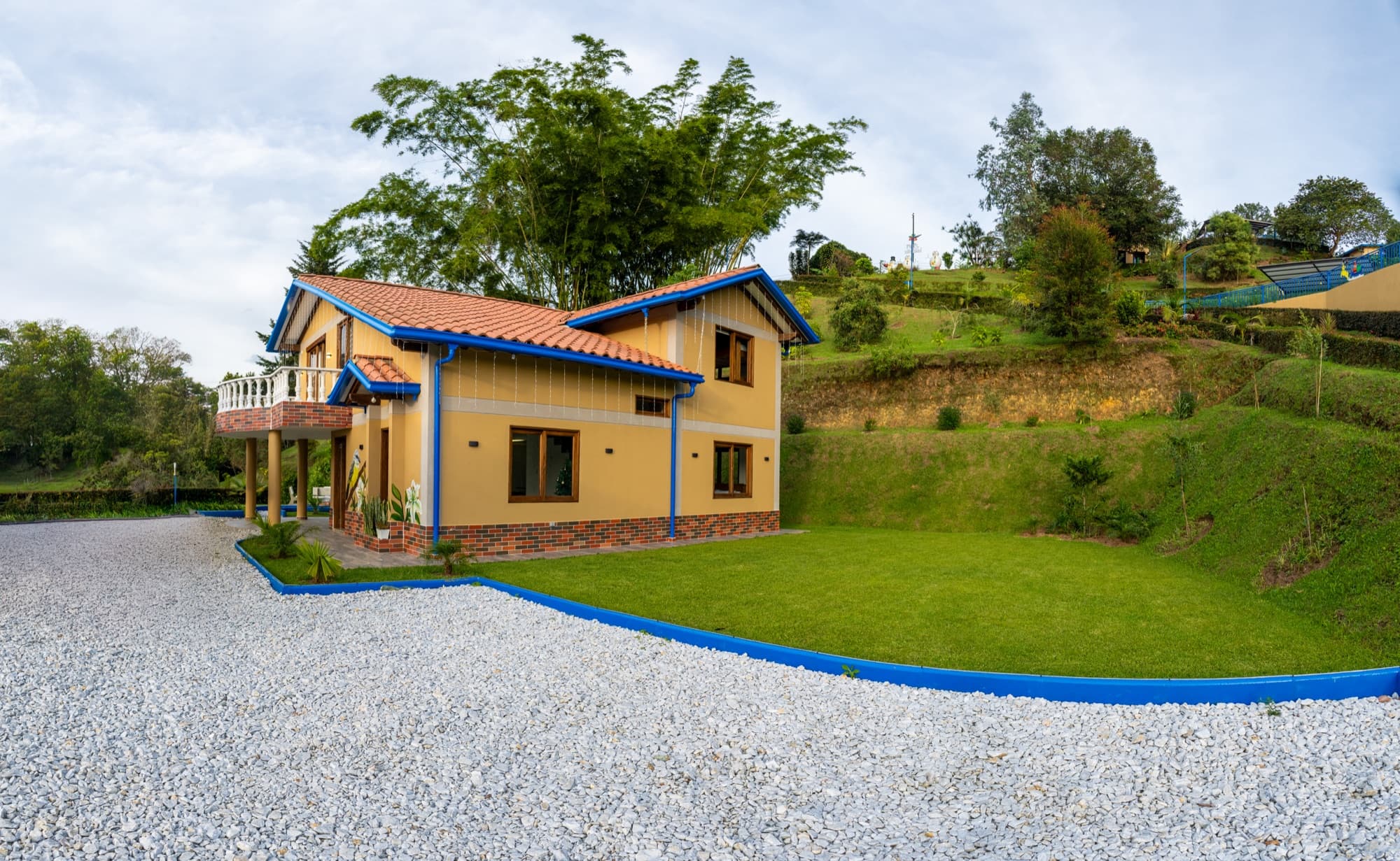Fachada de cabaña entre jardines