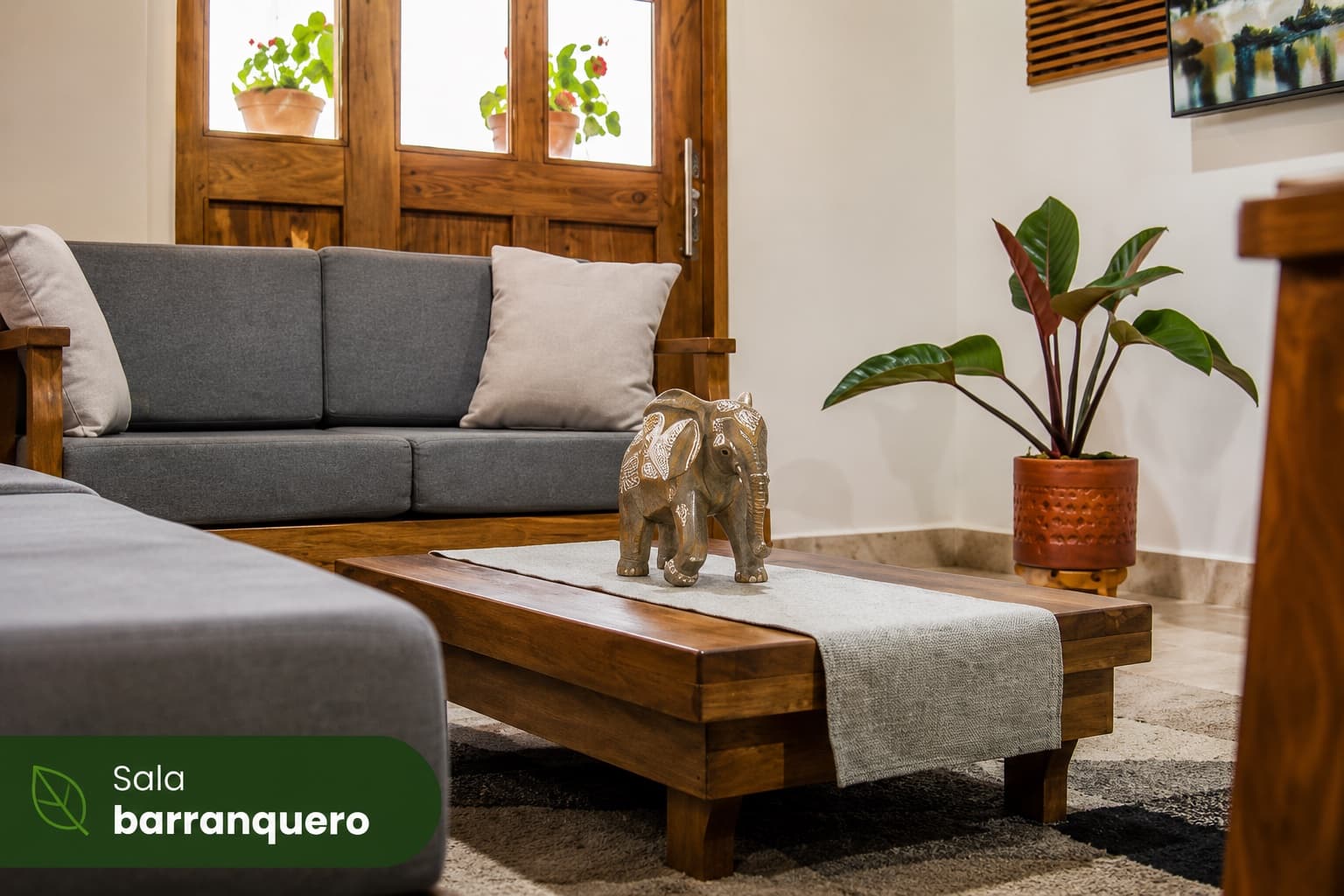 Sala de la Cabaña Barranquero con sofás de madera y plantas