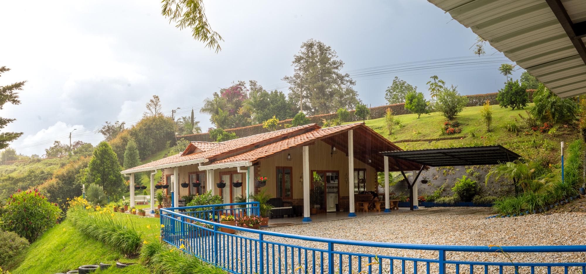 Fachada de la Cabaña Guacharaca con jardines y vista al valle